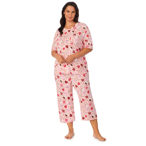 A lady wearing a pink elbow sleeve cropped pajama set plus with  latte pattern.