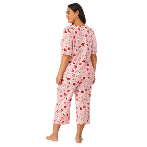 Pink Latte; Model is wearing size 1X. She is 5’11”, Bust 38”, Waist 34”, Hips 46”. @A lady wearing a pink elbow sleeve cropped pajama set plus with  latte pattern.