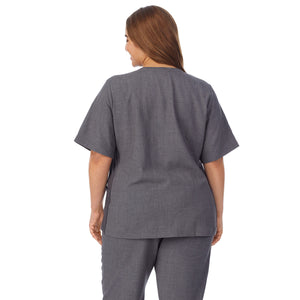  A lady wearing charcoal heather scrub split neck top plus.
